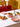 Coffret dîner Marobali mis en situation : saladier trapèze et 4 assiettes à taches rouges sur une table de fête