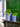 Duo de cache-pots Marobali à rayures bleues, grand et petit, sur une cheminée en marbre vert devant des carreaux émeraude